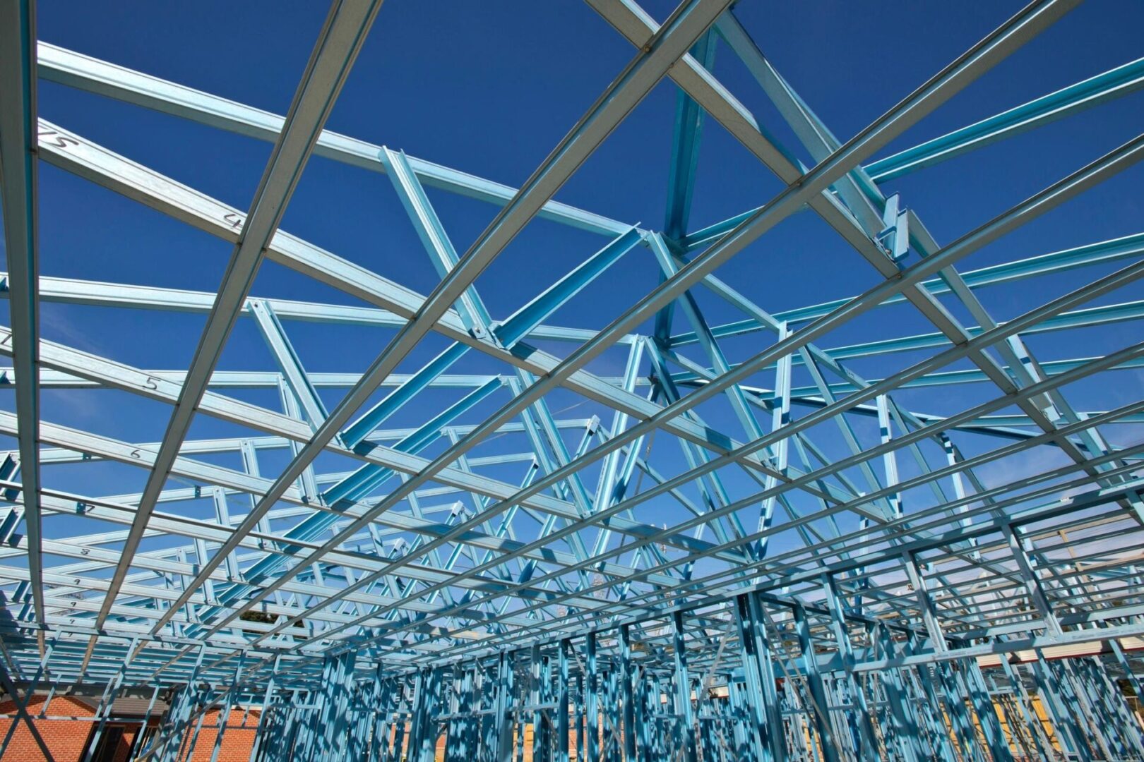 A blue metal structure with many blue ribbons hanging from it.
