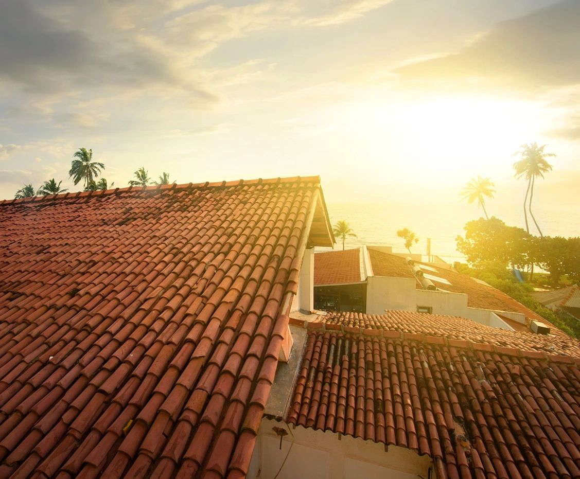 A roof with the sun setting in the background.