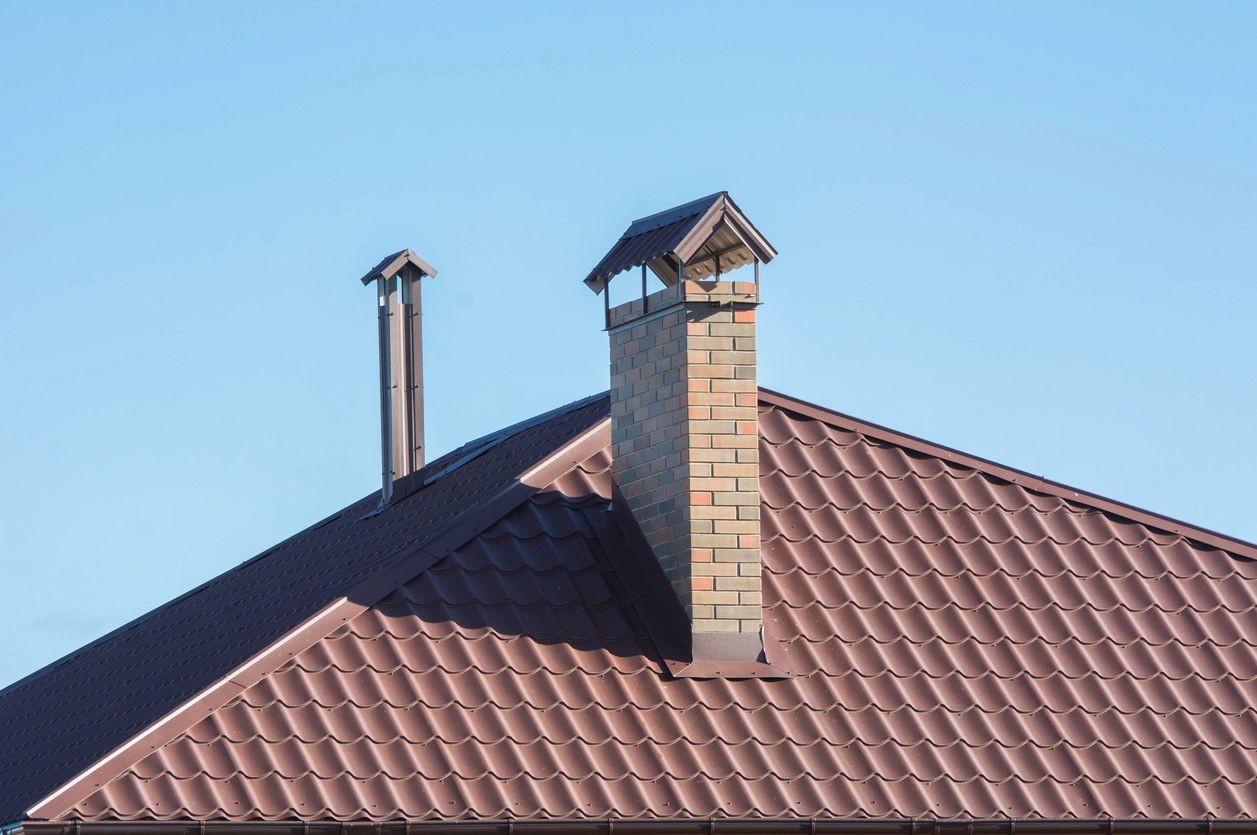 A brown roof with two chimneys on top of it.